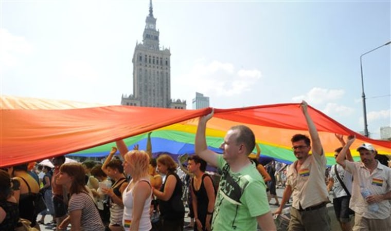 Participants carry a giant flag as they march in front of the Palace of Culture during the EuroPride gay parade in Warsaw, Poland on Saturday.